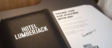 A black leather folder with "HOTEL LUMBERJACK" embossed on it, containing a thank you note for staying with the hotel.