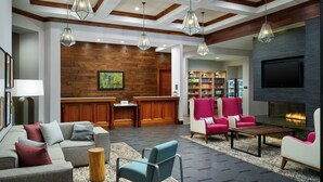 A modern lobby with a reception desk, seating area, and a fireplace. - Homewood Suites by Hilton Atlanta Midtown, GA (Atlanta)