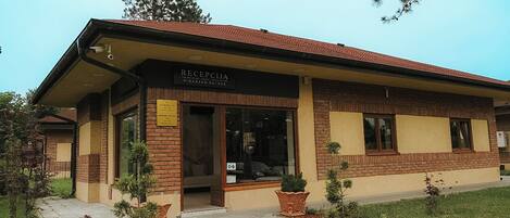 A building with a sign reading 'RECIPCIJA' and a brick facade.