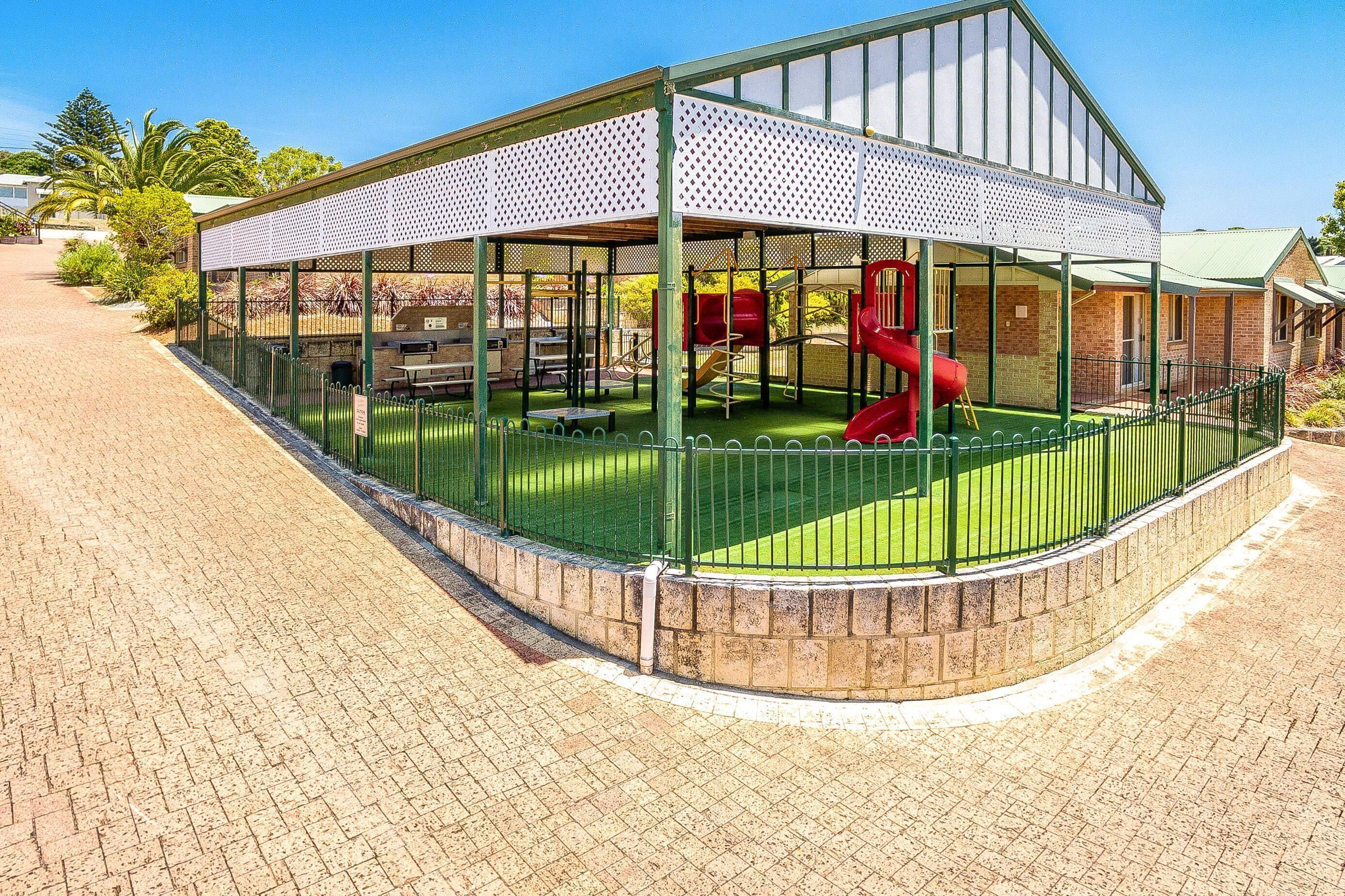 A covered play area with a slide and climbing structures.