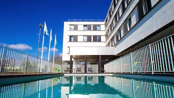 Una piscina al aire libre de temporada, sillones reclinables de piscina