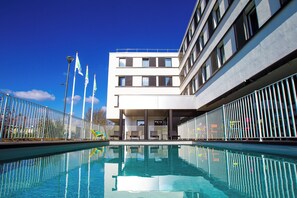 Un bâtiment moderne avec une piscine à l’avant.