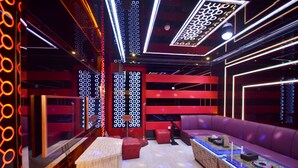 A modern interior with a red and black color scheme, featuring a seating area with a long table and a patterned wall. - Beijing Olympic Park Boutique Hotel (Beijing)