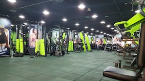 A gym with various exercise equipment, including weight machines and benches.