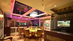 A dining area with a round table set for six, surrounded by chairs. - Beijing Olympic Park Boutique Hotel (Beijing)
