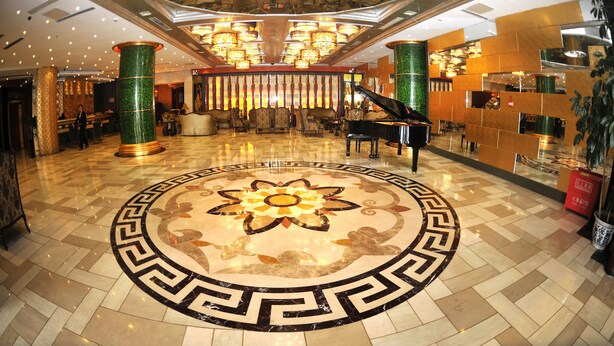 A grand lobby with a central floral floor design, a grand piano, and a high-ceiling with ornate chandeliers. - Beijing Olympic Park Boutique Hotel (Beijing)