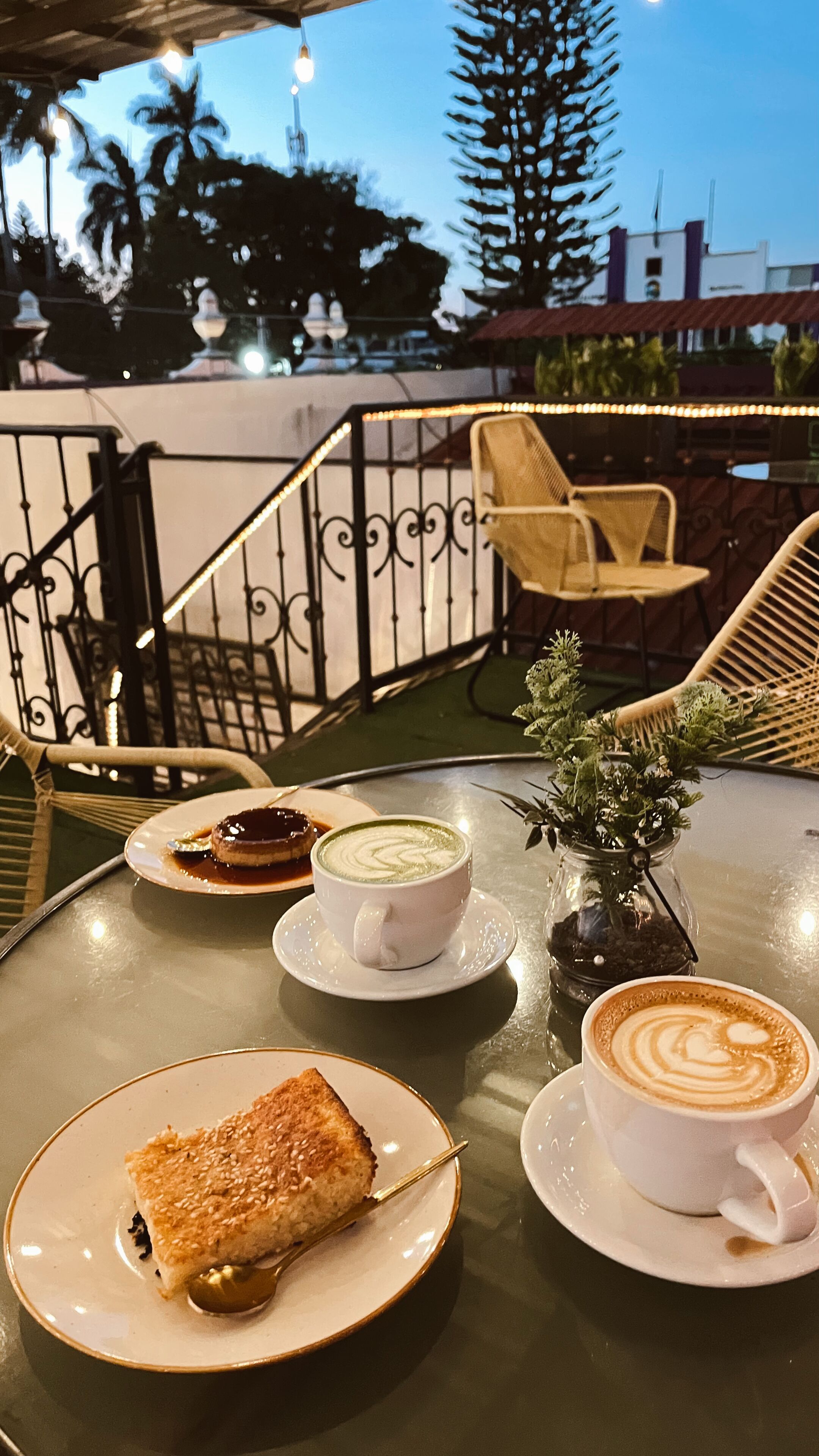 Une table avec une pâtisserie, une tasse de café et une petite plante.