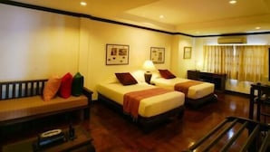 A hotel room with two beds, a desk, a chair, and a staircase. - Cucumber Inn (Pattaya)