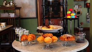 Un bufé de desayuno con bollería, café y un molinillo de café.
