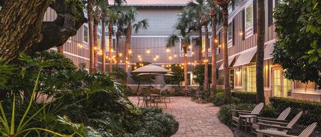An outdoor patio area with a brick pathway, seating, and string lights.