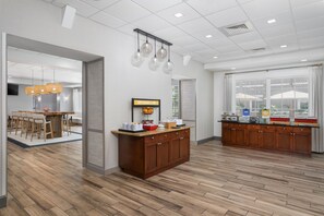 A modern kitchen with wooden cabinets, a breakfast bar, and pendant lighting. - Hampton Inn New Smyrna Beach (New Smyrna Beach)