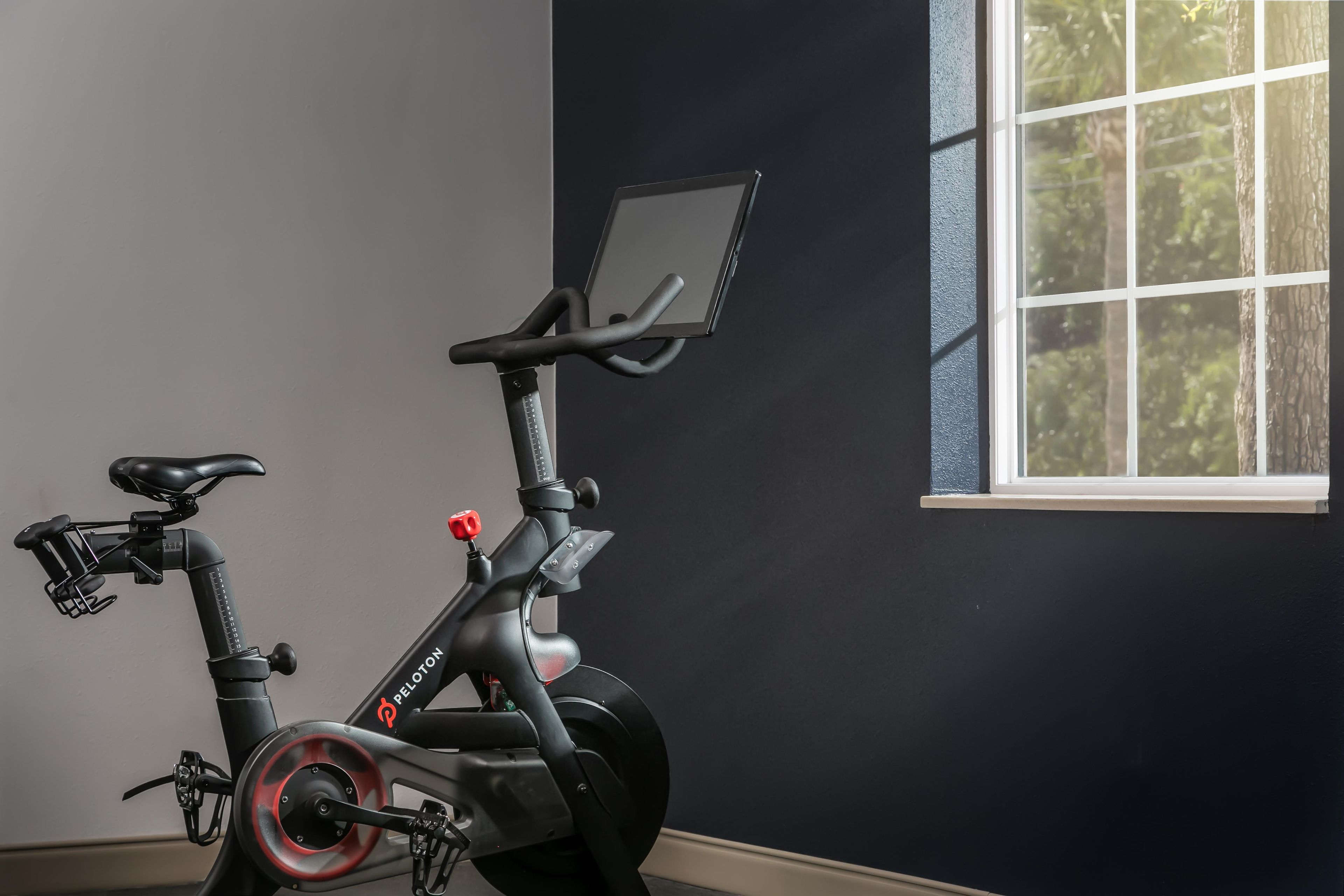 A stationary bike with a digital display, a seat, handlebars, and pedals.