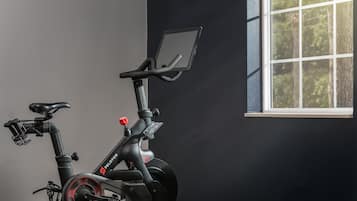 A stationary bike with a digital display, a seat, handlebars, and pedals.