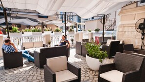 An outdoor seating area with wicker furniture and potted plants.
