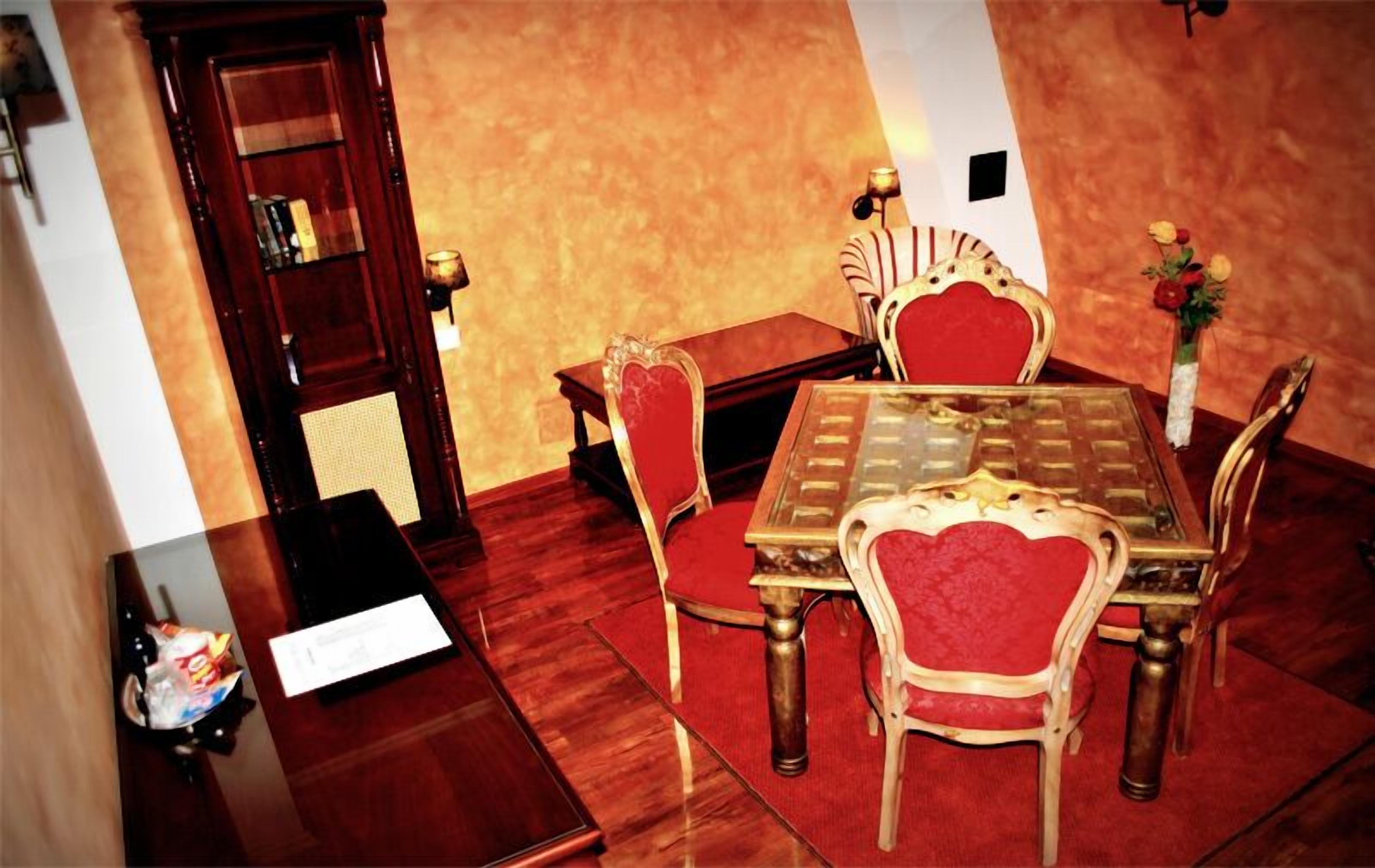 Un coin repas avec une table en bois, des chaises à revêtement rouge et une table avec un plateau en verre.