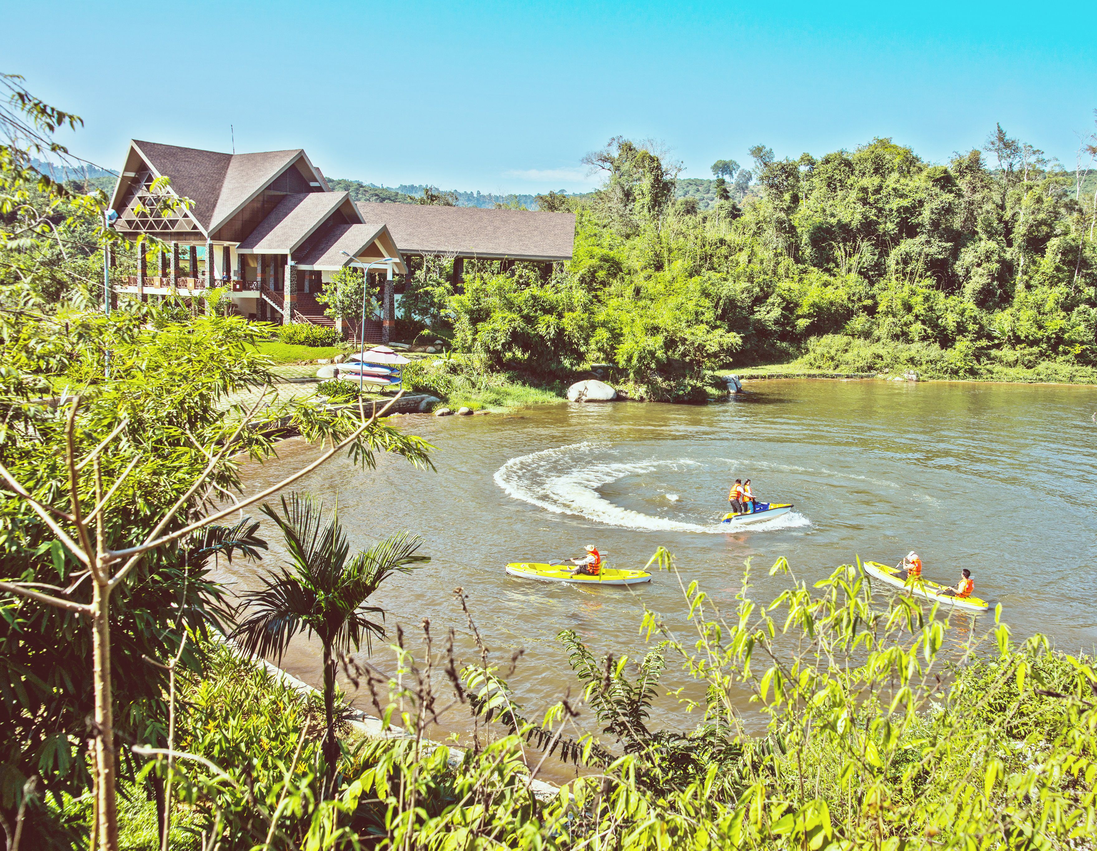 A riverside lodge with a large house and a covered area.