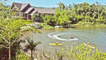 A riverside lodge with a large house and a covered area.