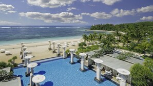 A resort pool with a view of the beach and ocean. - The Mulia Bali (Nusa Dua)