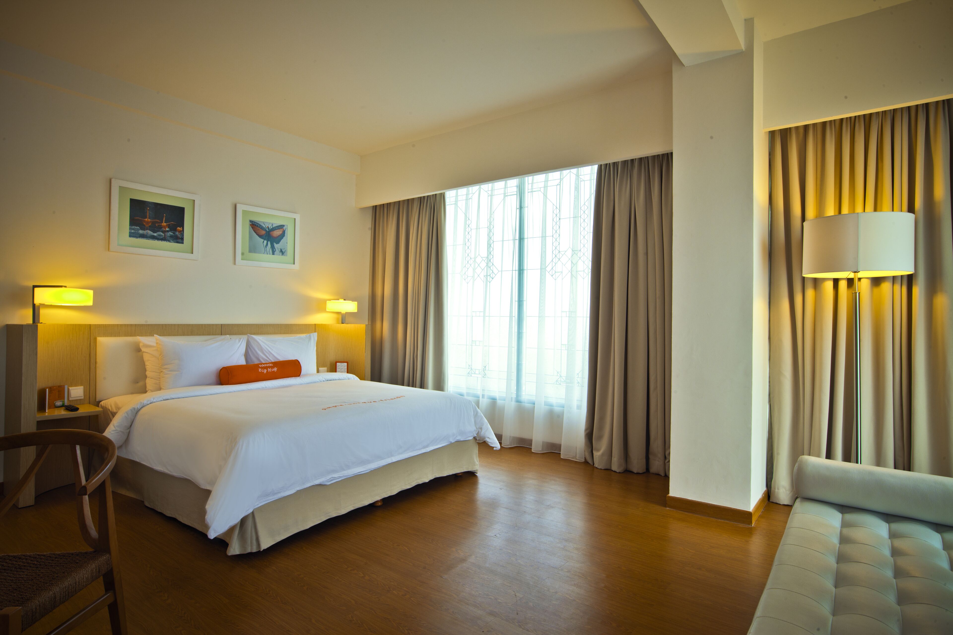 Ein Hotelzimmer mit einem großen Bett, einer Couch, einem Schreibtisch und einer Lampe.