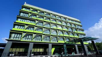 Un edificio moderno de varios pisos con una fachada geométrica distintiva y grandes ventanales.