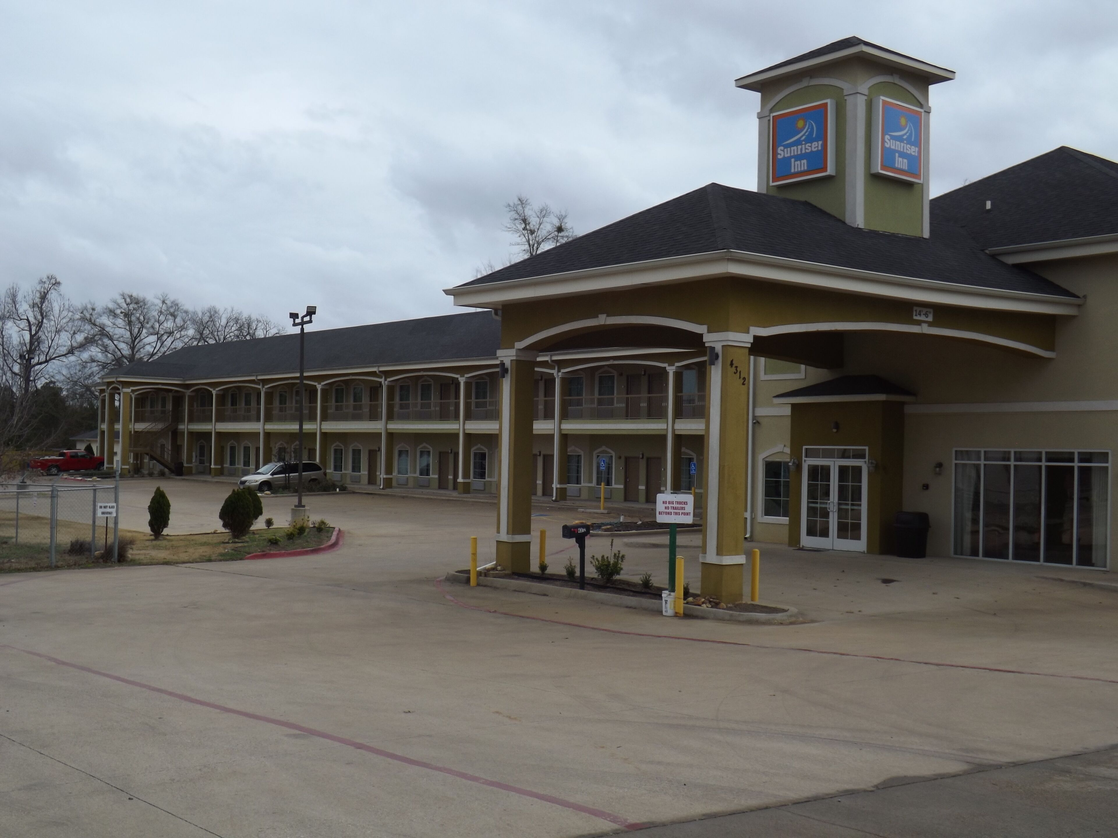 A Sunriser's Inn with a two-story building, a covered entrance, and a parking lot.