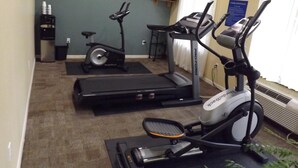 A fitness room with a treadmill, stationary bike, and elliptical machine. - SUNRISER INN (Kilgore)