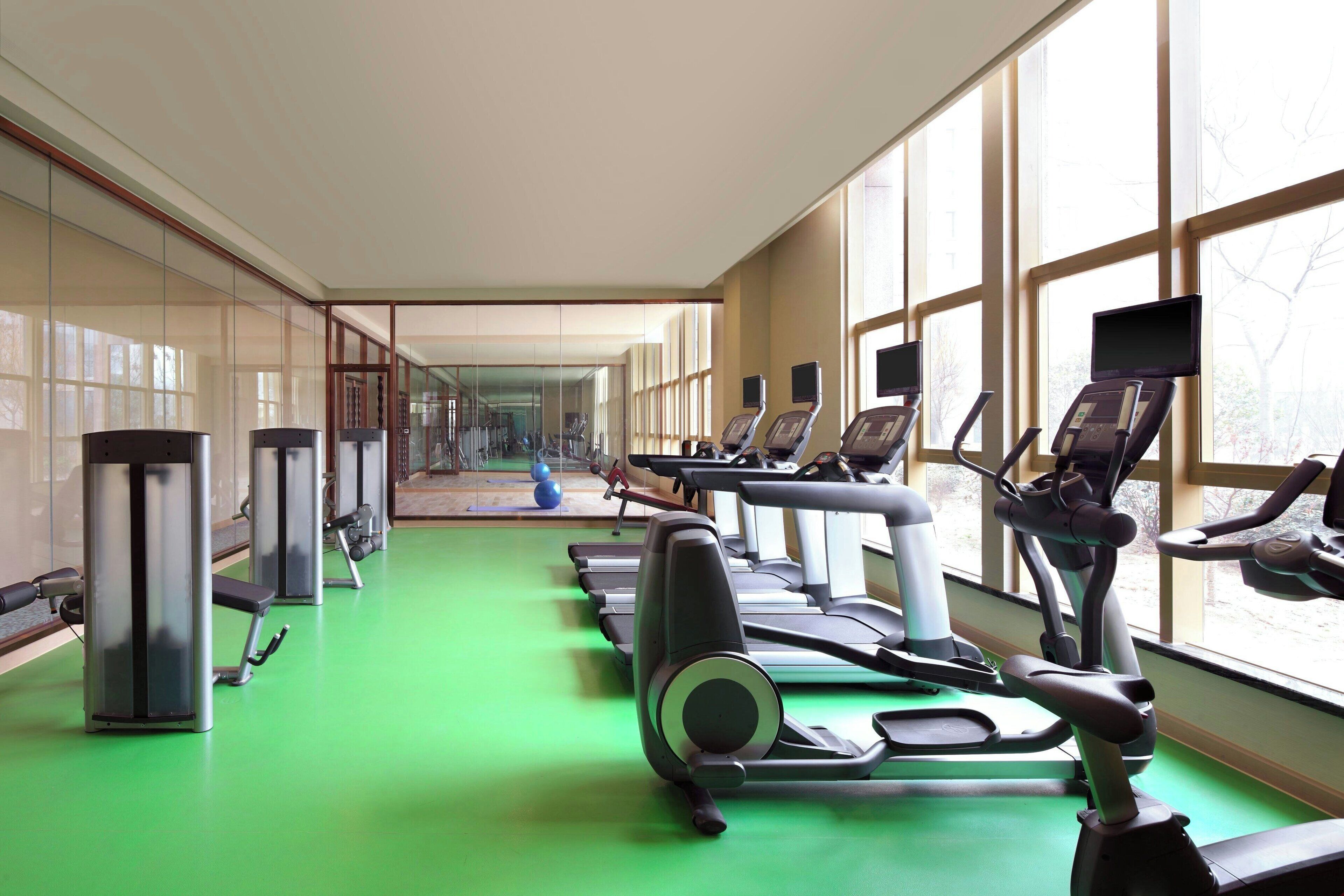 A gym with treadmills, elliptical machines, and weight machines.