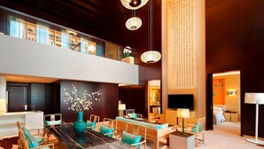 A spacious hotel lobby with a high ceiling, a central dining area with wooden furniture, and a large TV screen. - Four Points By Sheraton Luohe (Luohe)