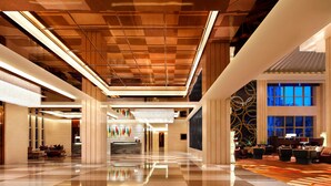 A spacious lobby with a checkered floor, a chandelier, and a seating area with sofas and a coffee table. - Four Points By Sheraton Luohe (Luohe)