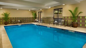 A swimming pool with chairs and potted plants around it. - Hampton Inn Cleveland, TN (Cleveland)