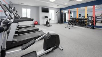 A gym with treadmills, a stationary bike, and weightlifting equipment.