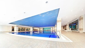 Une piscine intérieure dont le plafond est conçu pour ressembler à un ciel.