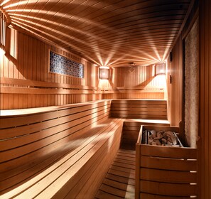 A sauna with wooden benches and a tiled wall. - Ramada Plaza by Wyndham Malatya Altin Kayisi (Malatya)
