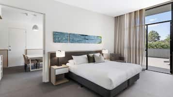 Ein modernes Hotelzimmer mit einem großen Bett, einem Schreibtisch und Blick ins Freie.
