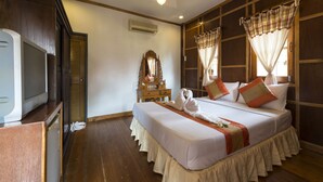 A hotel room with a bed, a television, a mirror, and curtains. - Grand Sea Beach Resort (Ko Pha-ngan)