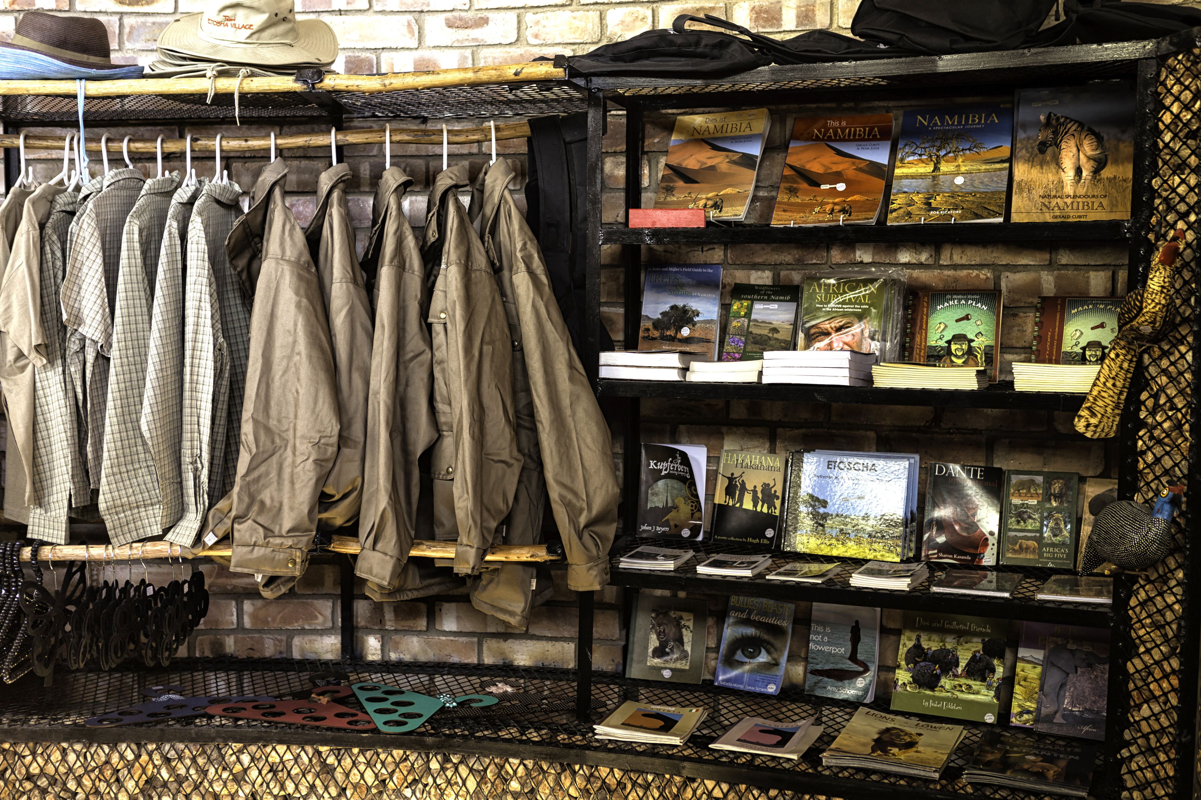 A bookstore with shelves of books and hanging jackets.