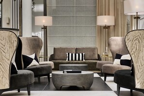 Una sala de estar moderna con un sofá, dos sillones, una mesa de centro y dos lámparas de pie.