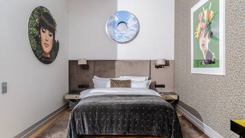 Quarto moderno com cama grande, decoração circular na parede e padrão de leopardo.