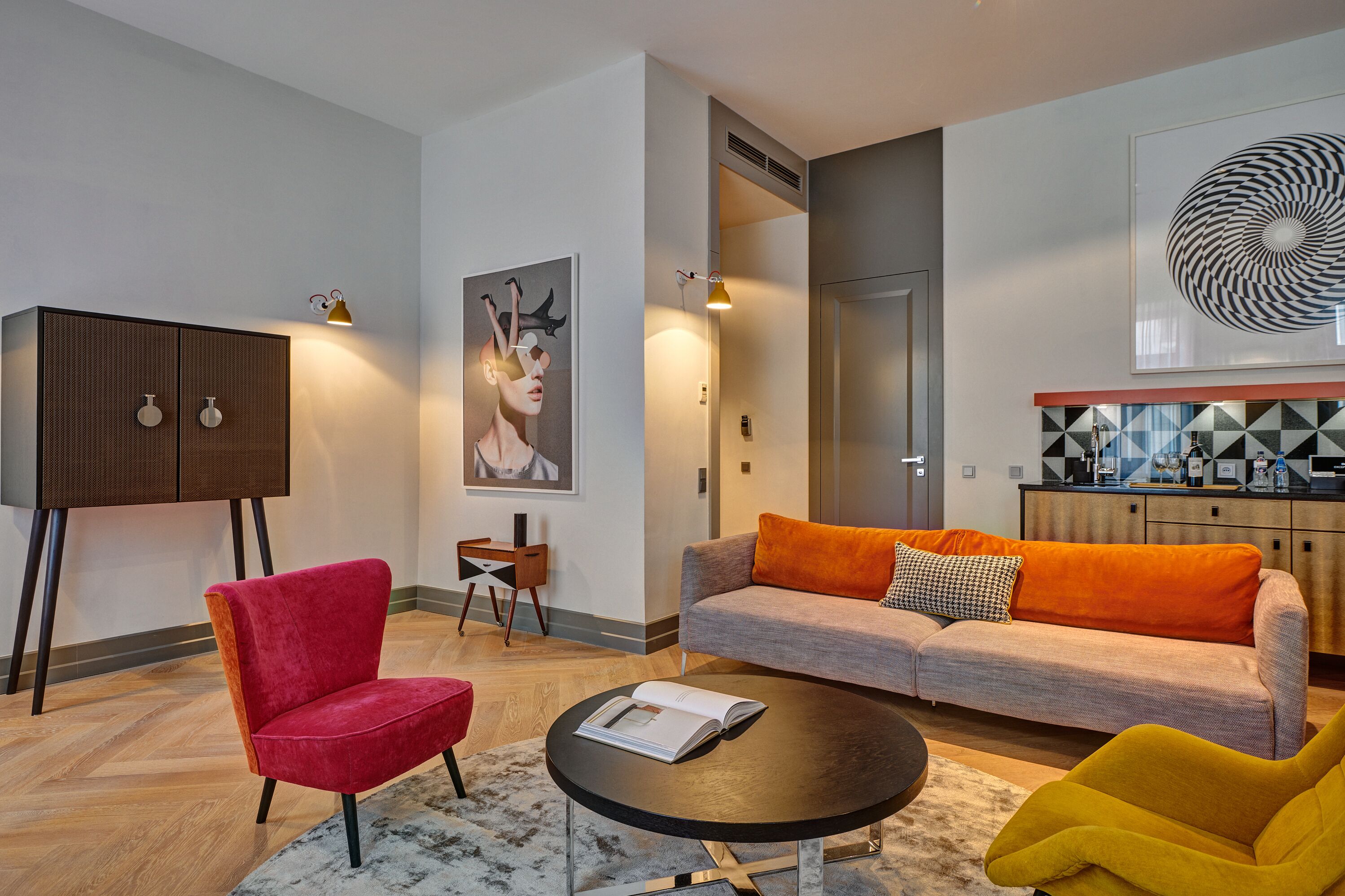 A modern living room with a sofa, armchairs, a coffee table, and a cabinet.