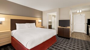 Une chambre d’hôtel avec un grand lit, une télévision, un bureau et une armoire.