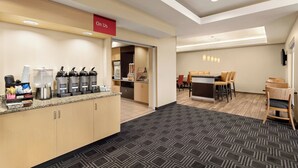 Un hall d’hôtel comprenant un coin café, un espace salon et un comptoir d’accueil.