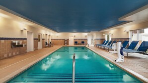 Une piscine intérieure avec des couloirs bien délimités, un vestiaire et des chaises longues.
