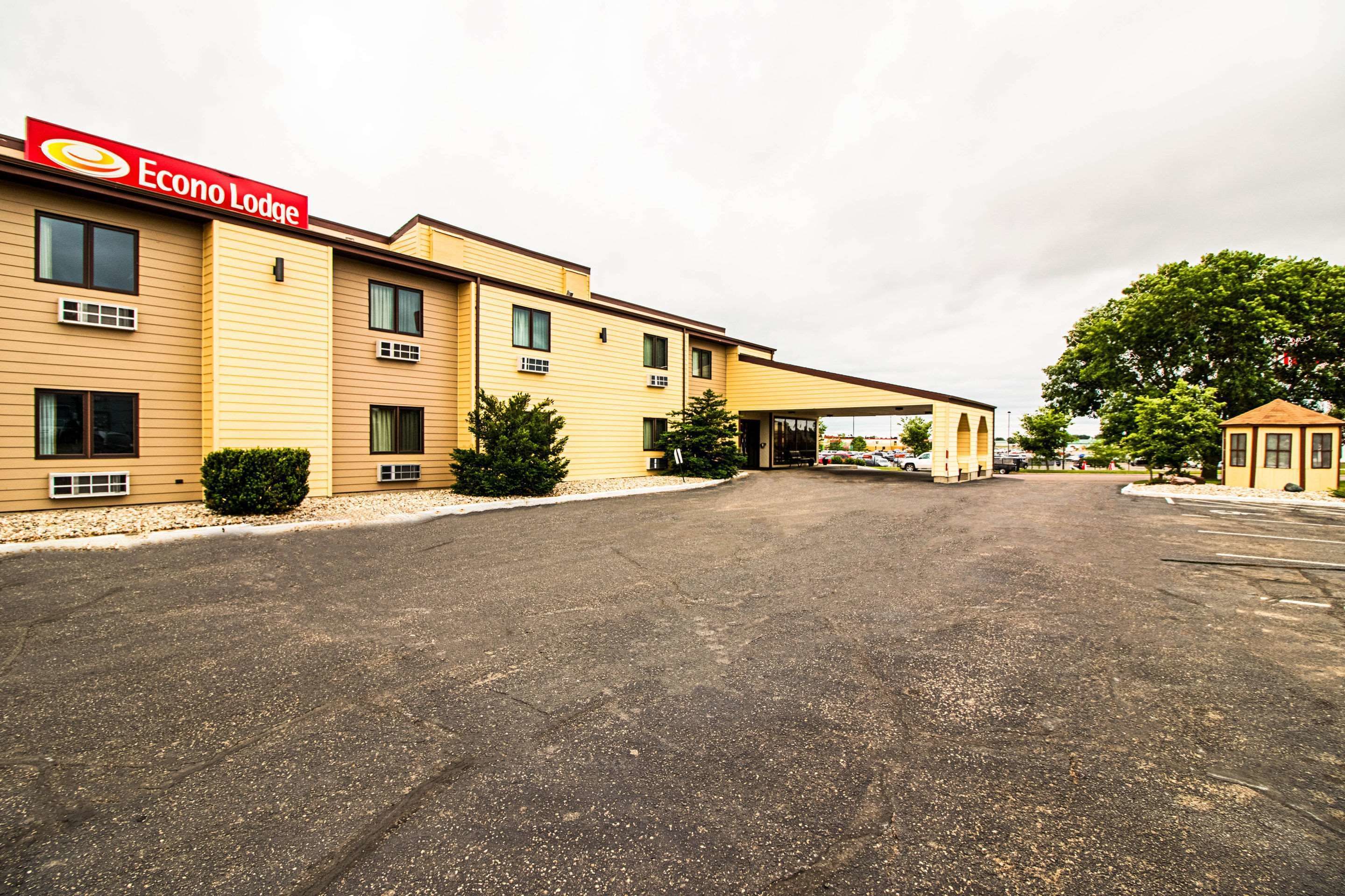 Un bâtiment Econo Lodge à deux étages, doté d’un espace de stationnement couvert et d’une petite structure adjacente.