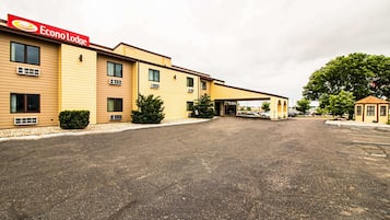 Ein zweistöckiges Econo Lodge Hotel mit überdachtem Parkplatz und einem kleinen Nebengebäude.