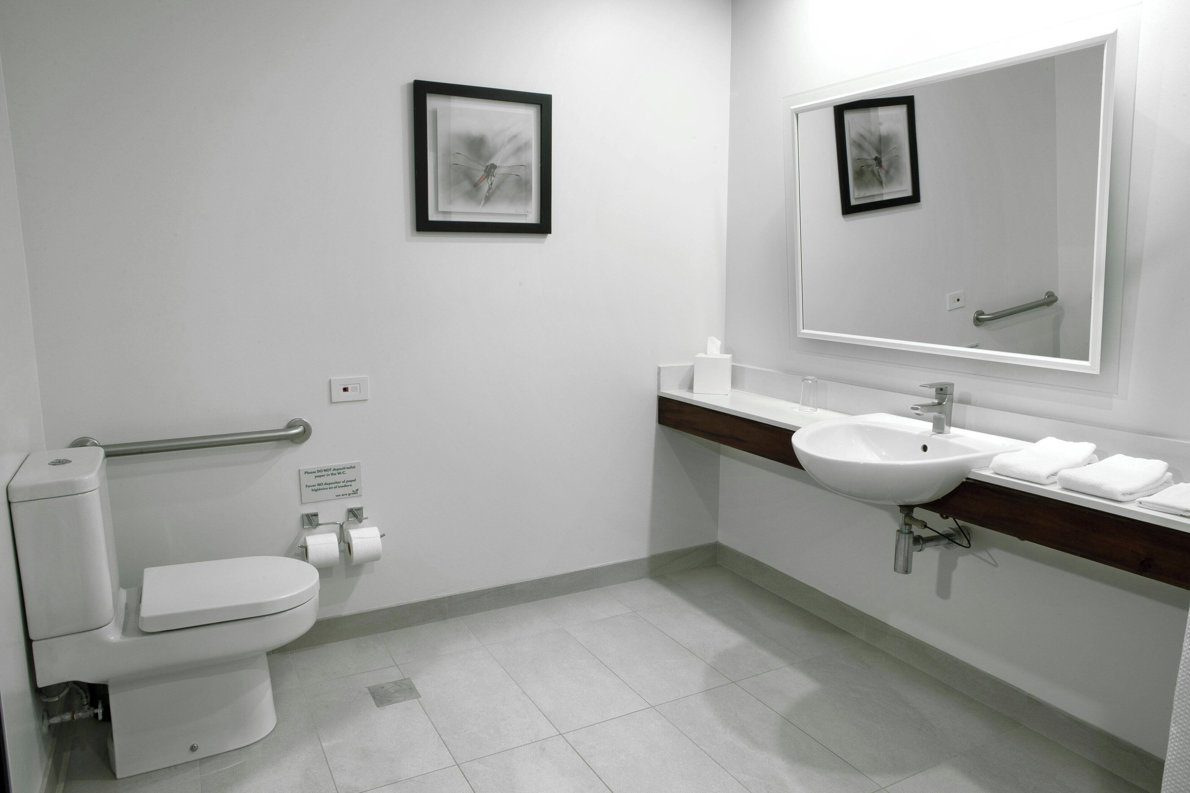 Et moderne badeværelse med toilet, vask og spejl.