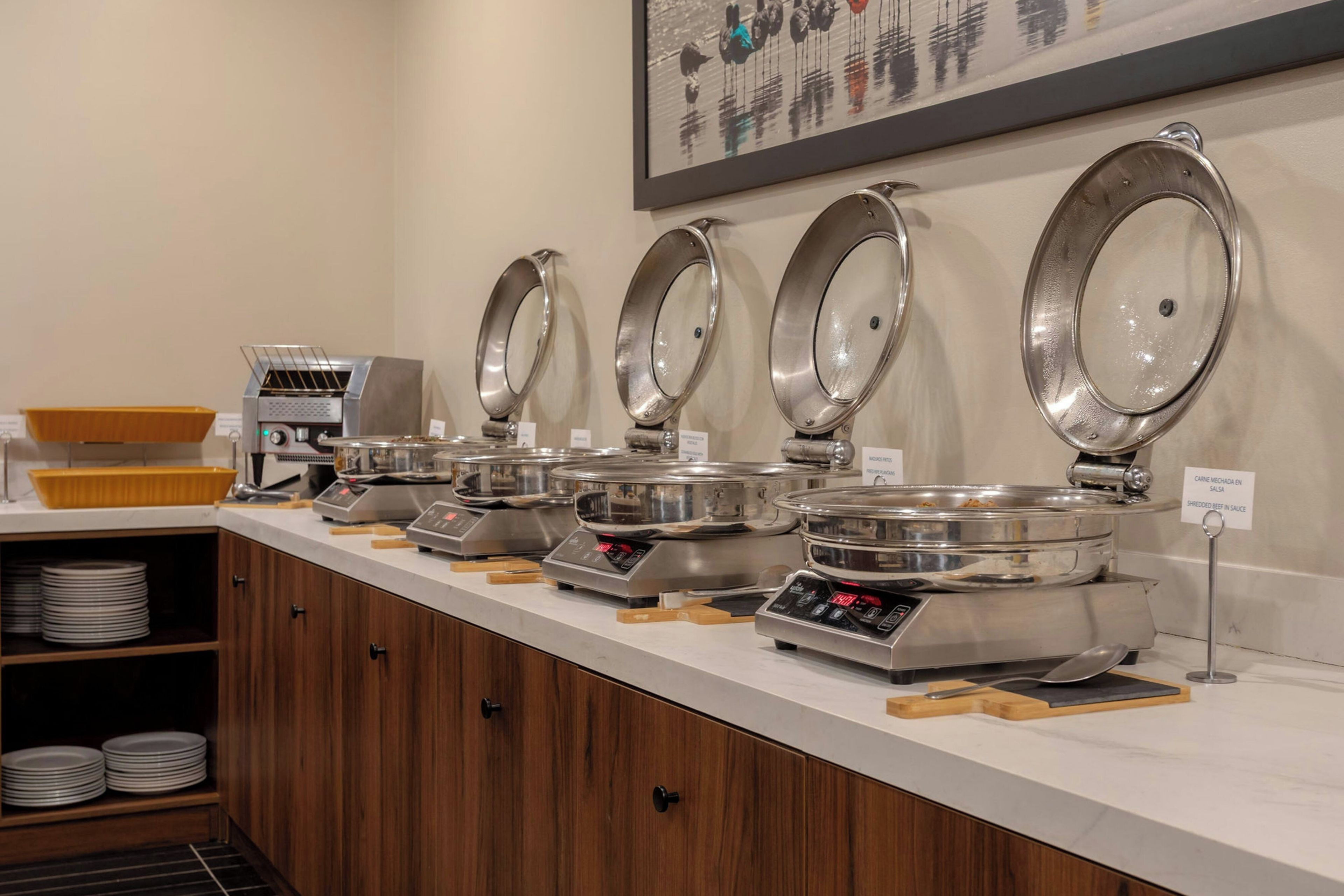 Disposição de buffet com diversas estações de serviço, cada uma com tampa e balança digital.