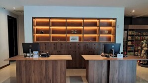 A reception desk with two HP monitors, a wooden panel with the Marriott Bonvoy logo, and a plush toy on the right. - Four Points by Sheraton San Jose Sabana (San José)