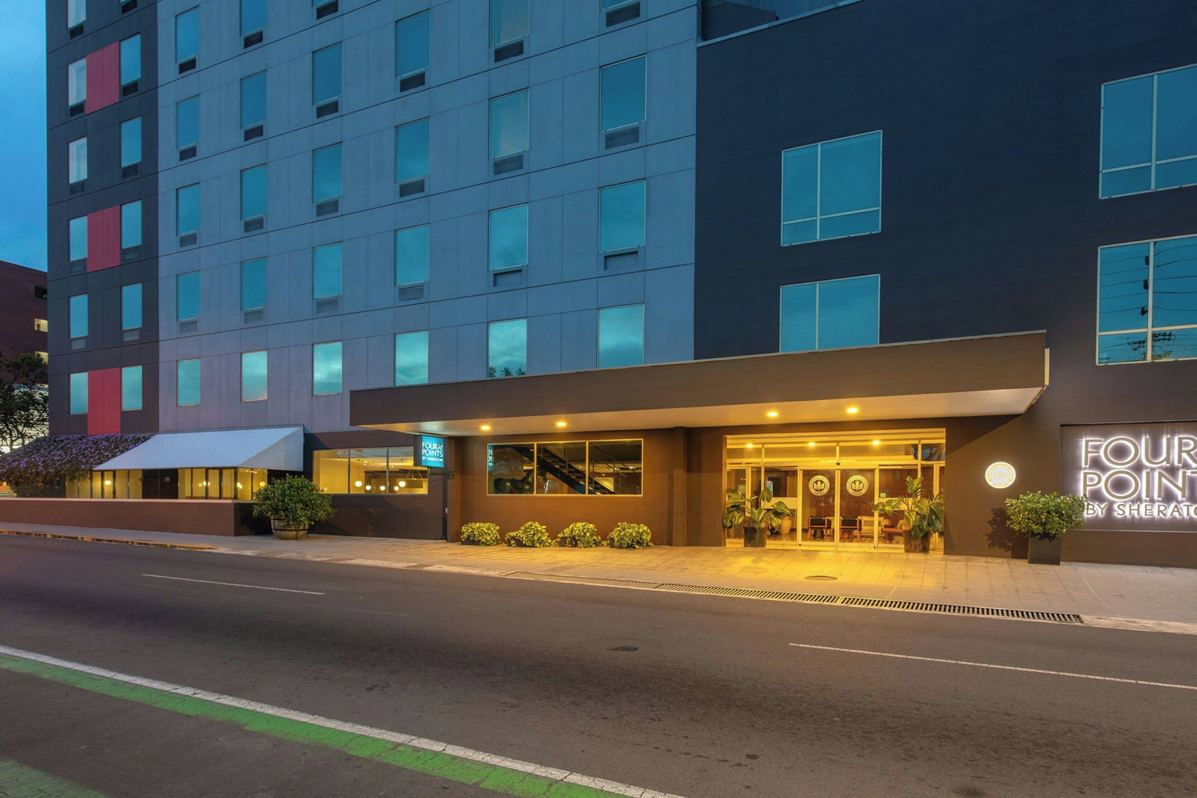 A multi-story hotel with a modern facade, a well-lit entrance, and a visible sign for 'Four Points by Sheraton.'
