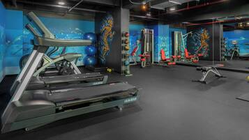 A gym with treadmills, weight machines, and exercise balls.