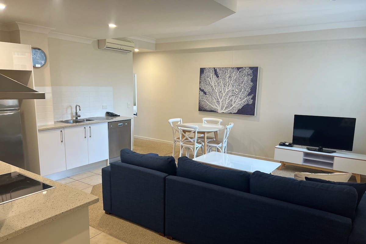 A modern apartment with a kitchen, dining area, and living room.